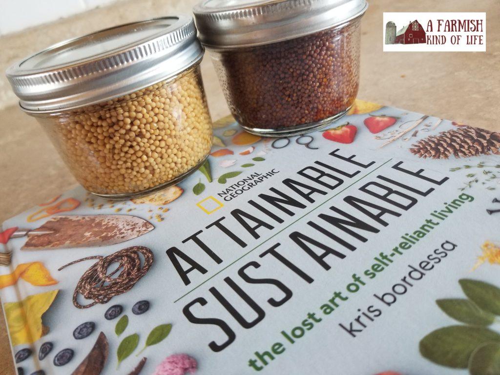 Two jars of mustard seeds sitting on the book, "Attainable Sustainable" by Kris Bordessa.